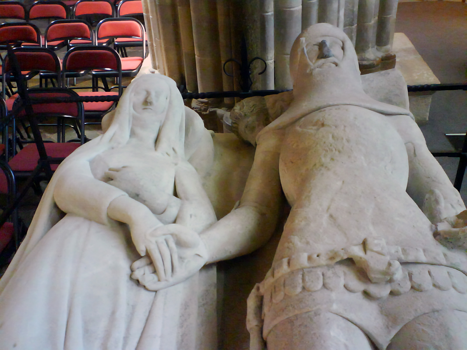 The Arundel Tomb in Chichester Cathedral: two recumbent white stone effigies of Eleanor of Lancaster and Richard FitzAlan lying side by side, their hands clasped together — the image that inspired Philip Larkin's poem "An Arundel Tomb."
